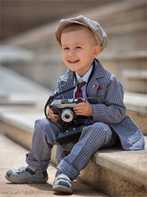 A little boy sitting with camera ready to take a picture