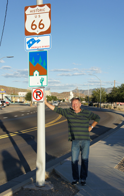 A photo of a man next to the Route 66 road sign